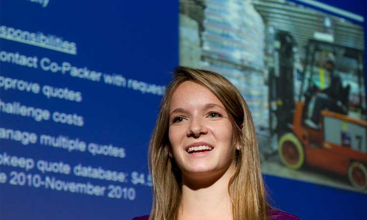 Female student presenting in front of projection screen