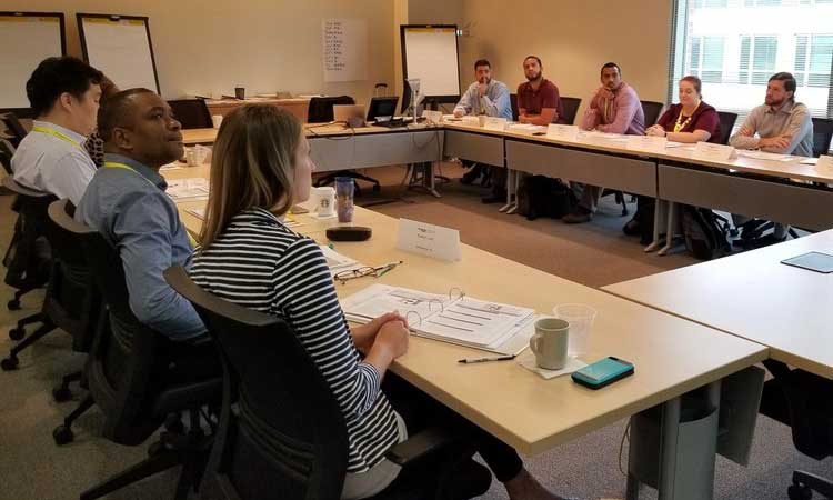 Groups of students around tables setup in room for training