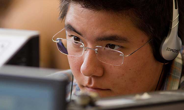 Student with headphones on participating in web conference