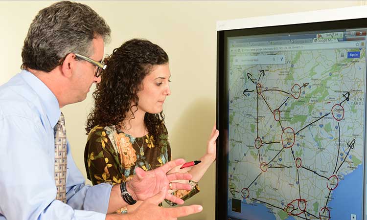 Benoit Montreuil and PhD student in front of large computer monitor